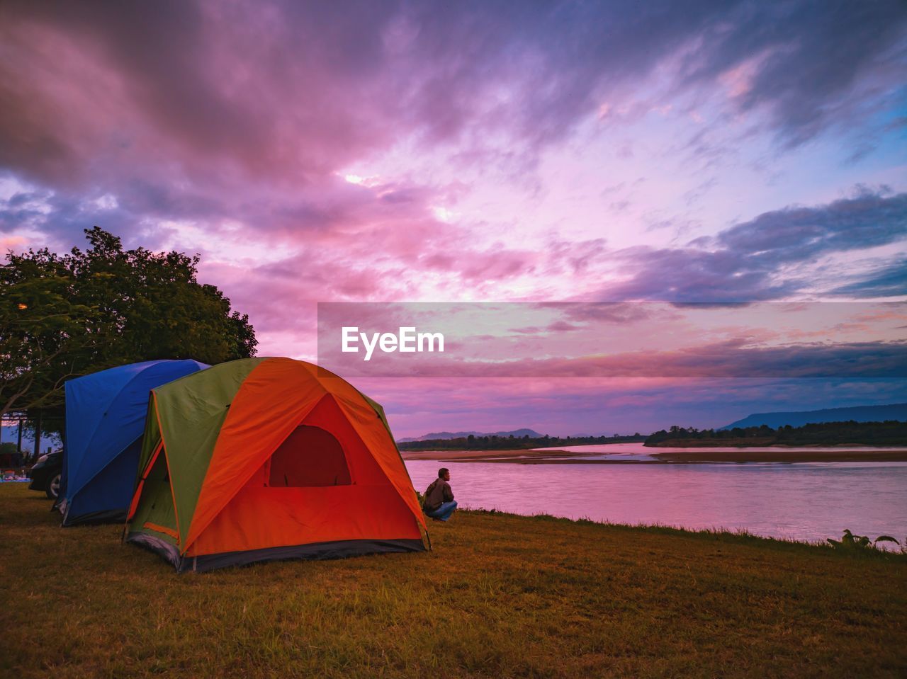 TENT ON FIELD AGAINST SKY DURING SUNSET