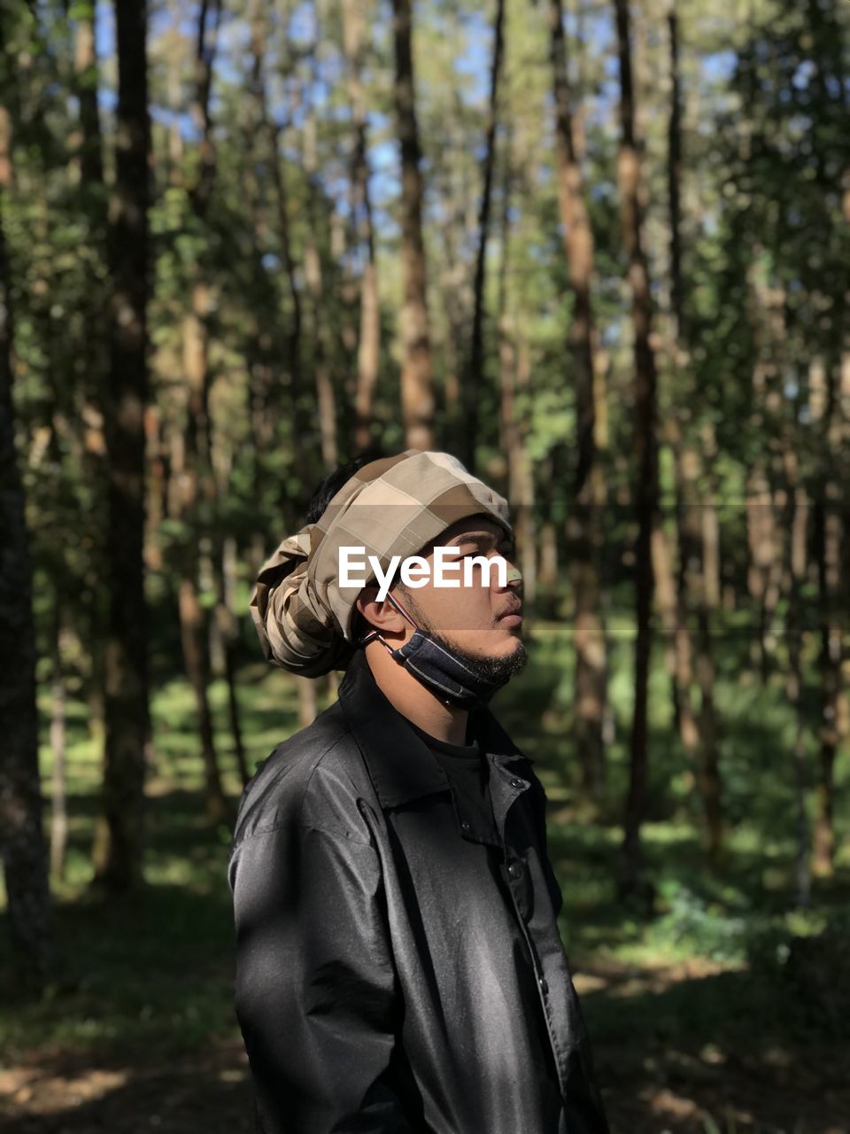 Young man looking away in forest