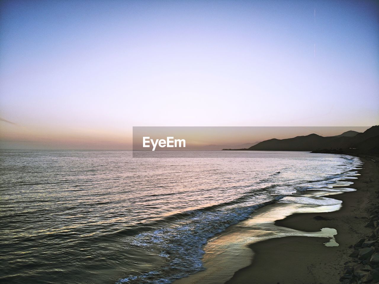 Scenic view of sea against clear sky during sunset