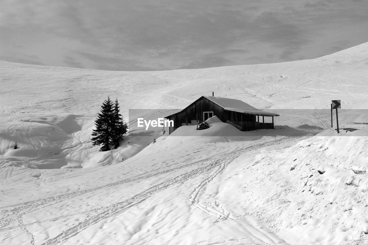 Snow covered land and mountain against sky