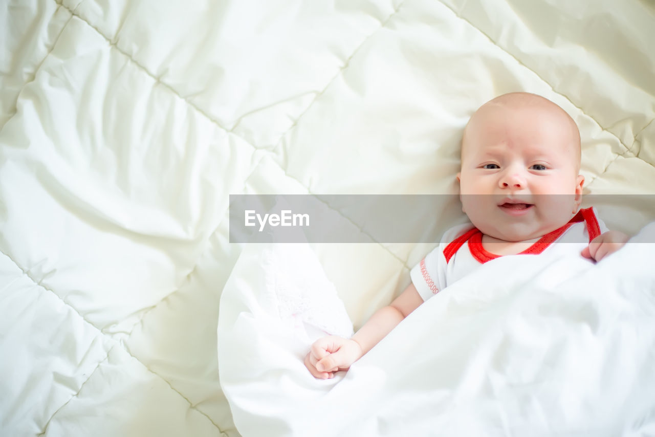 high angle view of cute baby boy sleeping on bed