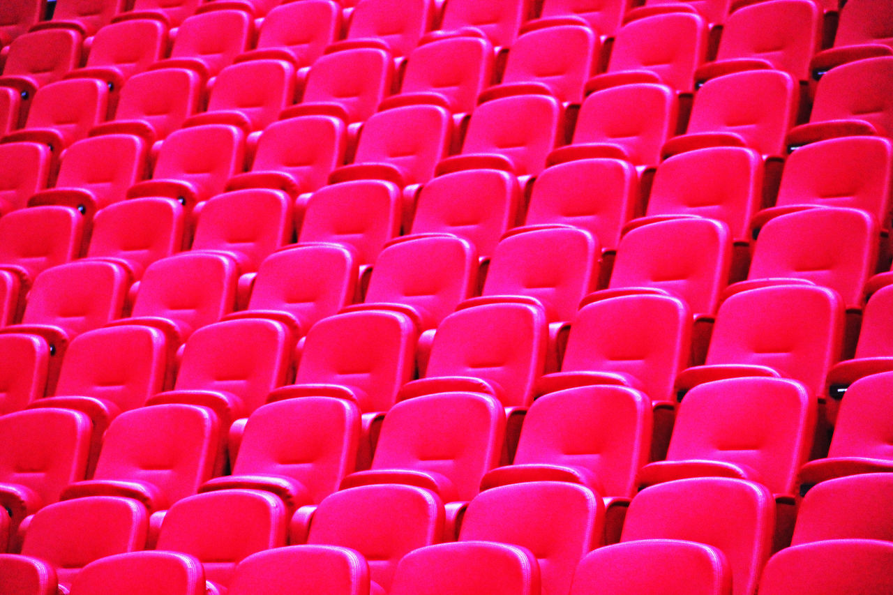 in a row, red, seat, full frame, backgrounds, repetition, no people, chair, large group of objects, empty, order, pattern, side by side, arts culture and entertainment, abundance, line, arrangement, sports, absence, stadium, auditorium, pink