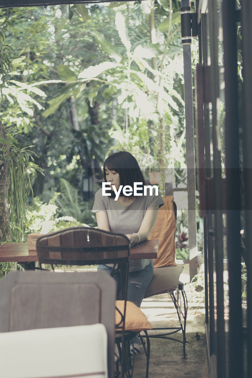 WOMAN SITTING ON CHAIR