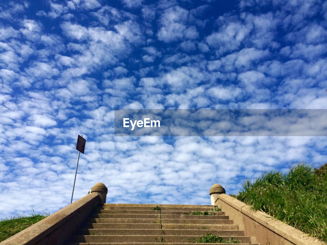 Steps leading towards cloudy sky