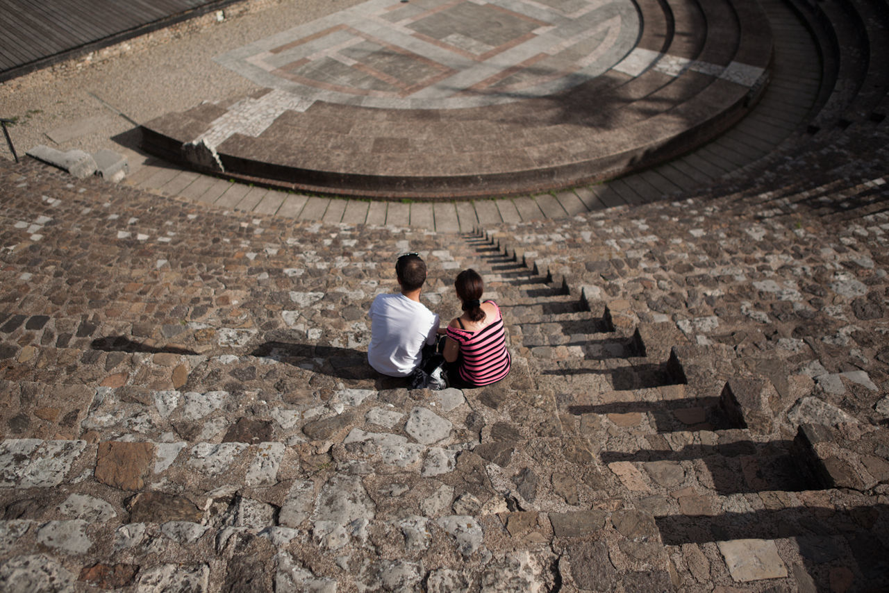 High angle view of couple sitting at amphitheater steps