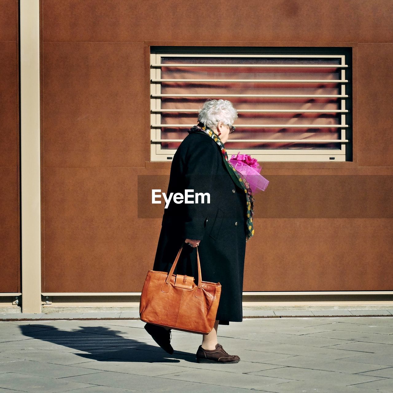 WOMAN STANDING AGAINST WALL