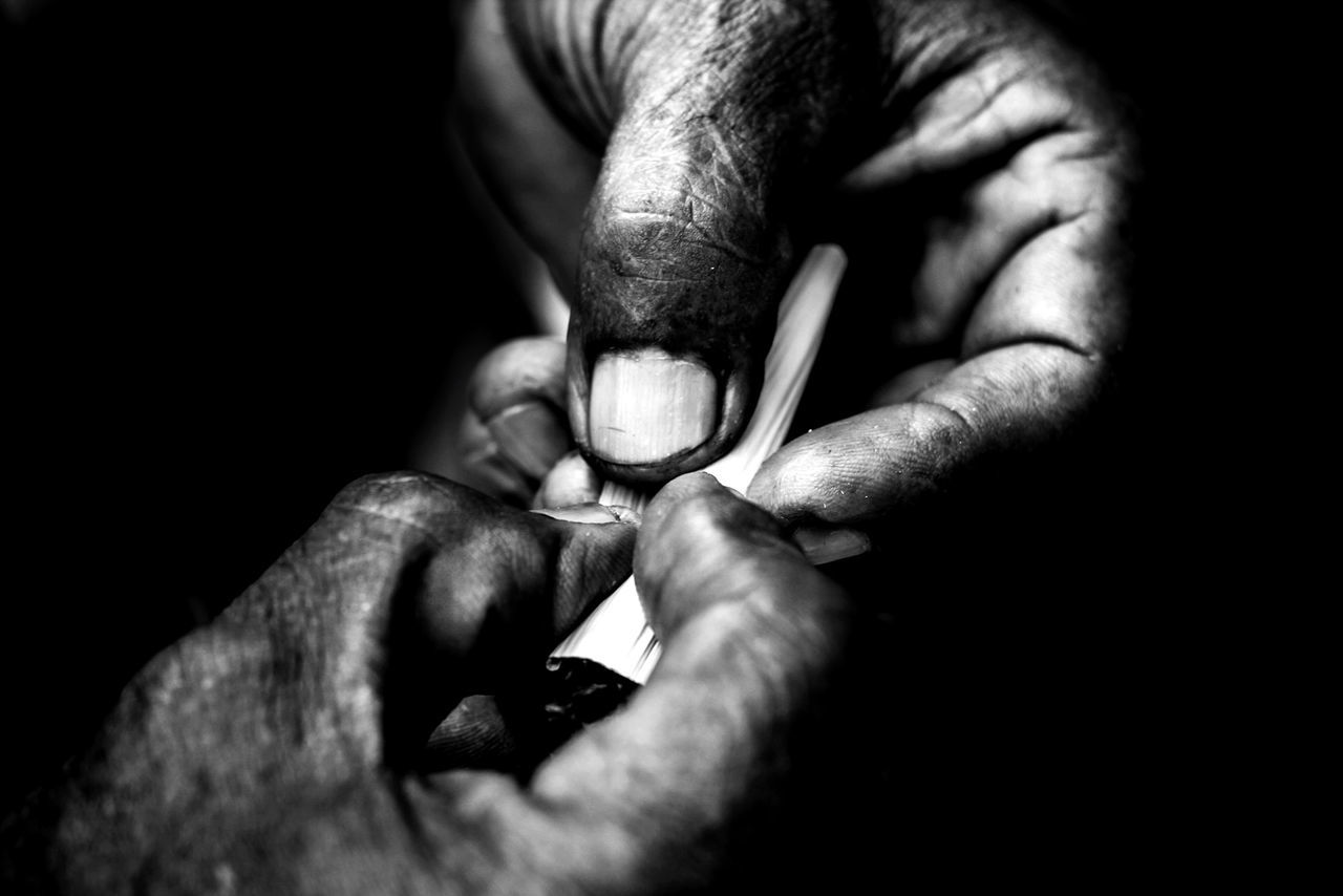 Cropped image of hands making joint in darkroom