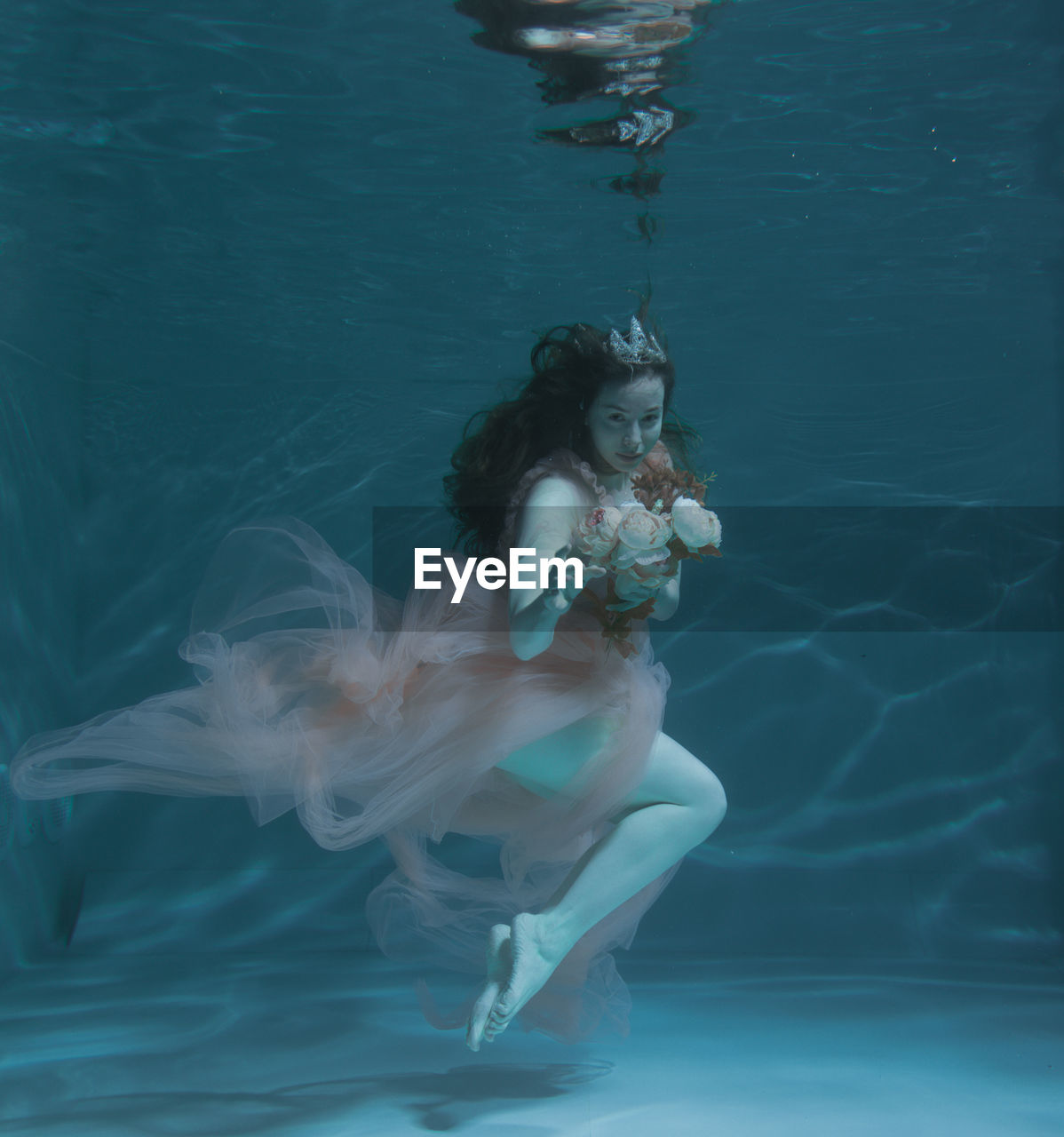 WOMAN SWIMMING UNDERWATER IN POOL
