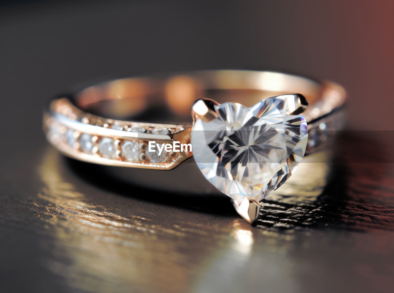 Golden ring with diamond in the shape of heart with reflection