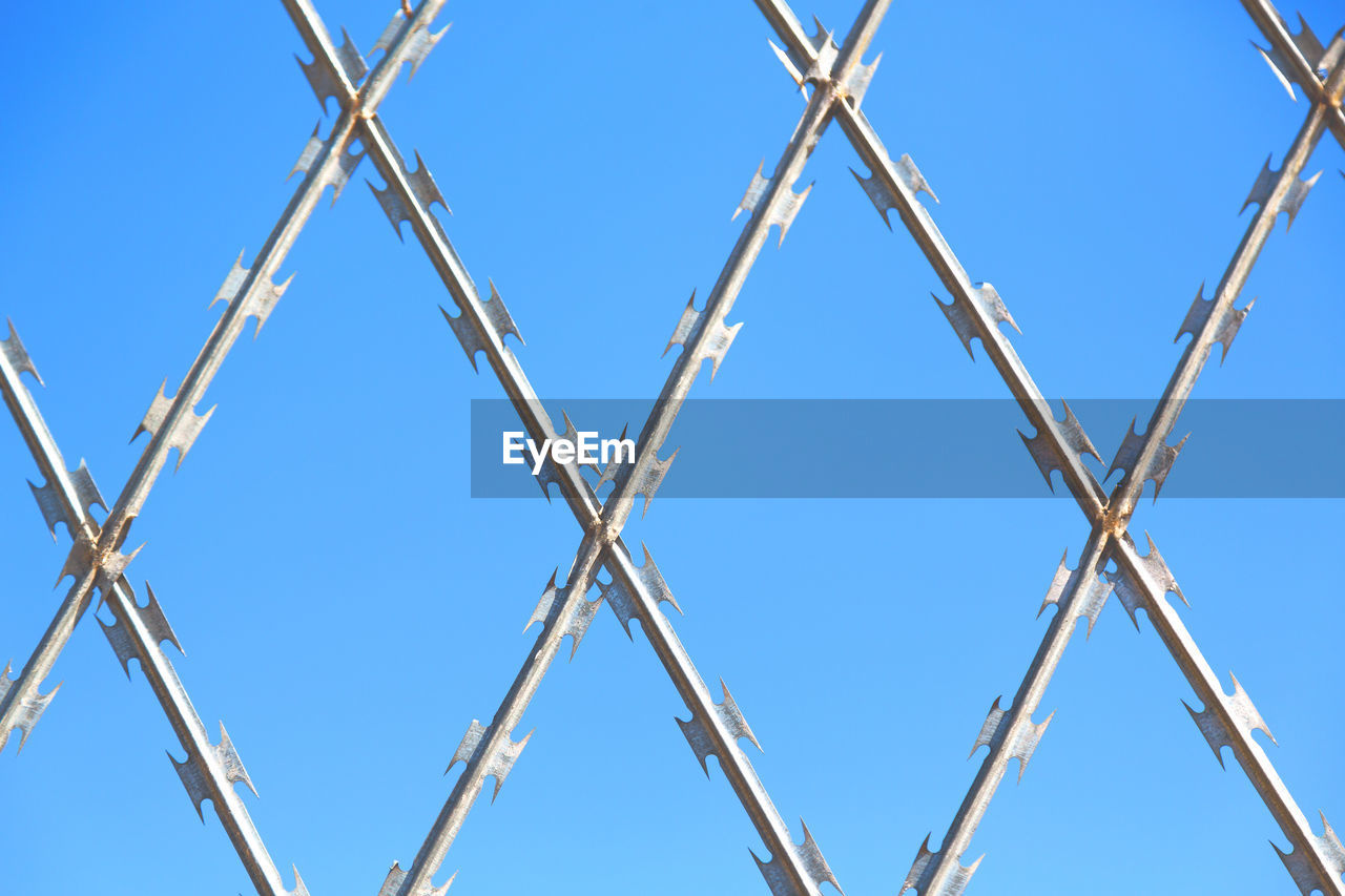 LOW ANGLE VIEW OF BARBED WIRE AGAINST CLEAR SKY