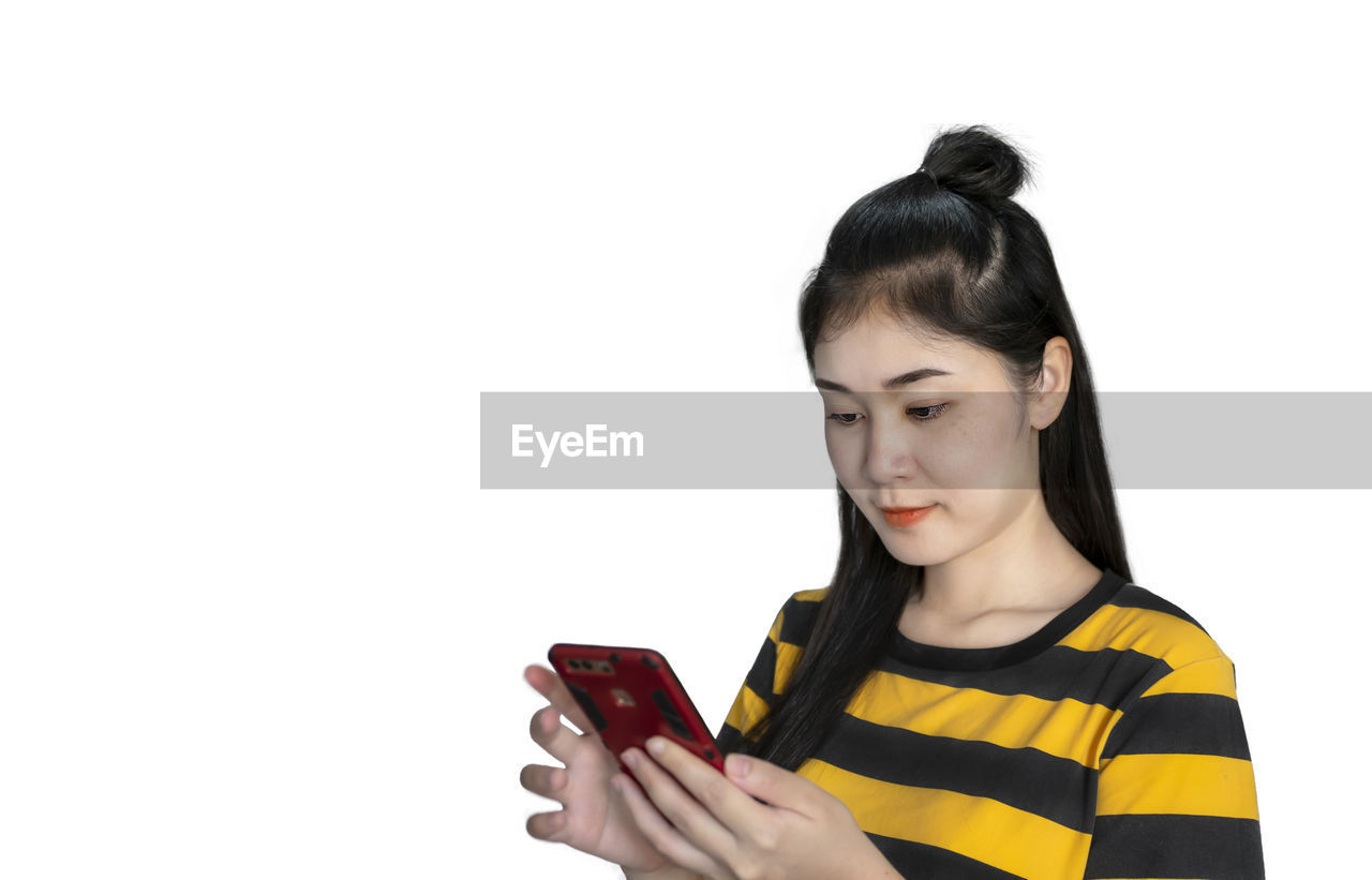 YOUNG WOMAN LOOKING AWAY WHILE HOLDING CAMERA