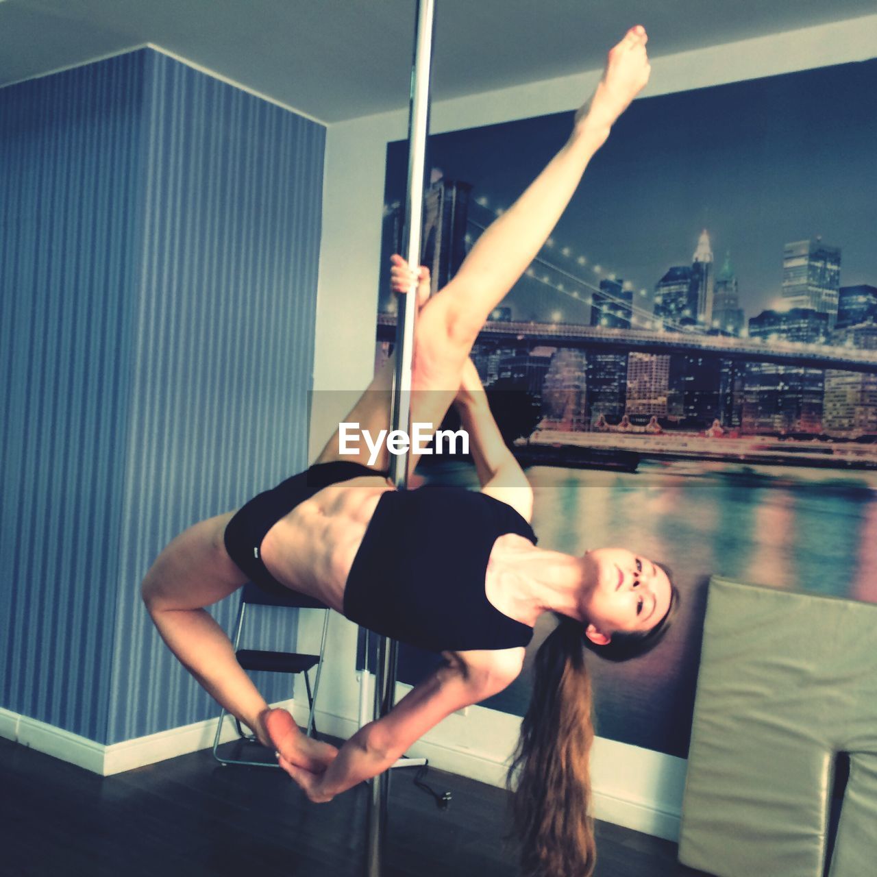 Woman performing gymnastics on pole