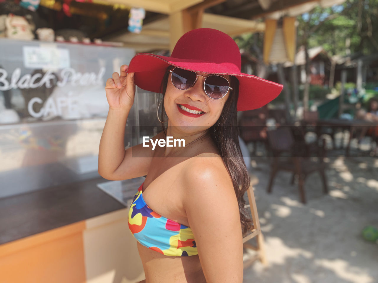 Portrait of smiling young woman wearing sunglasses standing outdoors