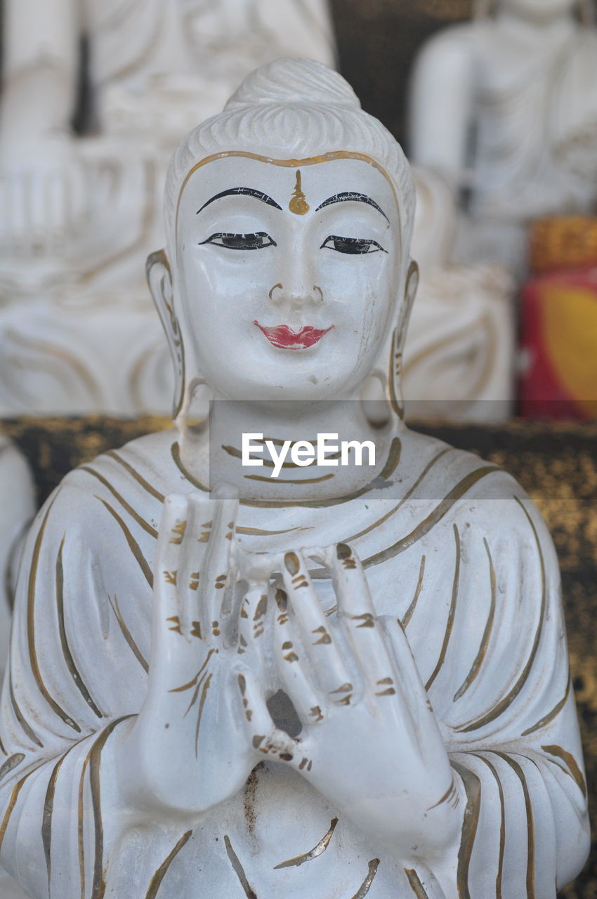 CLOSE-UP OF BUDDHA STATUE IN TEMPLE