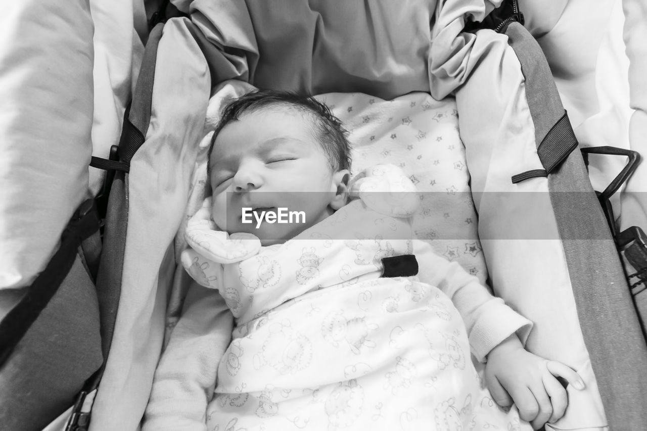 High angle view of baby relaxing on bed