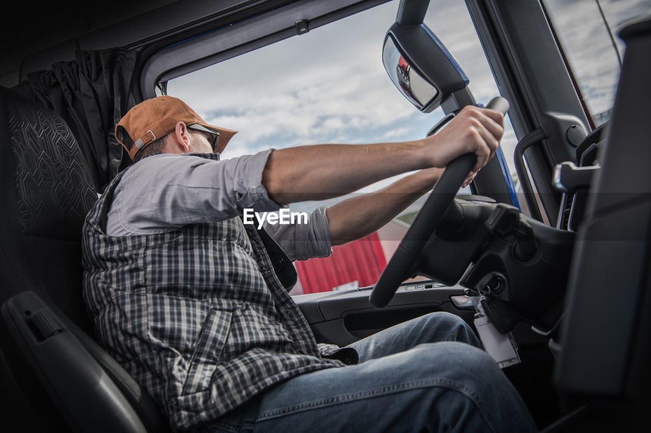 REAR VIEW OF MAN SITTING IN BUS