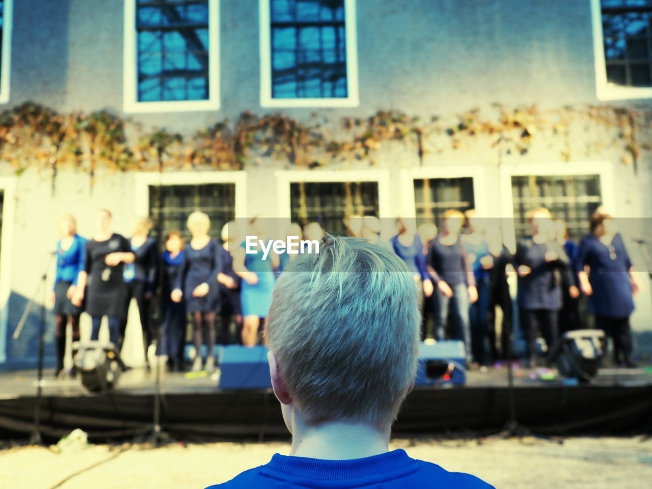 Rear view of boy looking at choir performance
