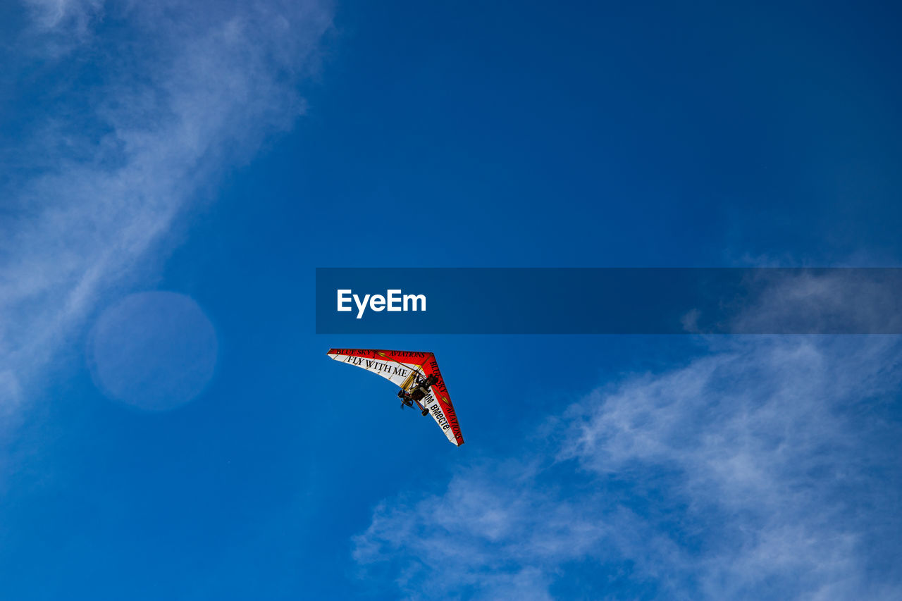 LOW ANGLE VIEW OF AIRPLANE AGAINST BLUE SKY