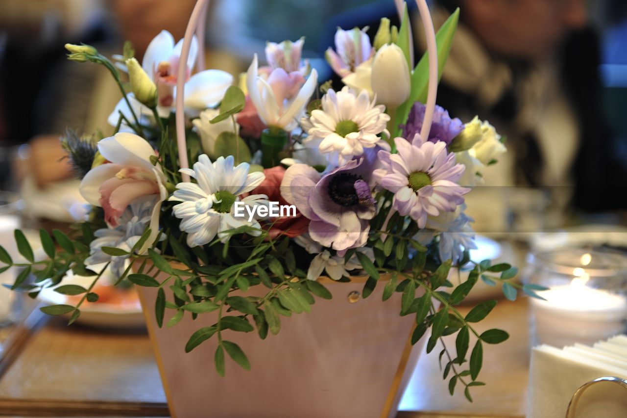 flower, flowering plant, plant, floristry, centrepiece, beauty in nature, flower arrangement, floral design, freshness, ceremony, nature, bouquet, table, wedding, arrangement, indoors, vase, close-up, candle, decoration, celebration, focus on foreground, business, flower head, selective focus, no people, bunch of flowers, meal, retail, event, fragility, furniture