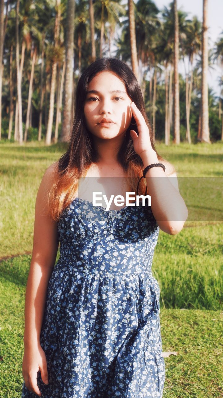 Portrait of young woman standing on field