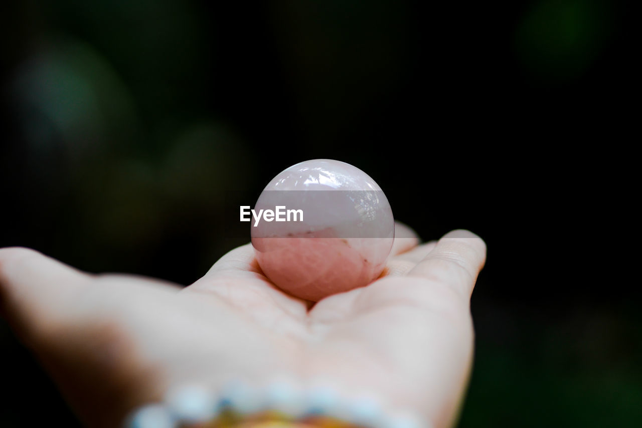 CLOSE-UP OF PERSON HOLDING CRYSTAL BALL