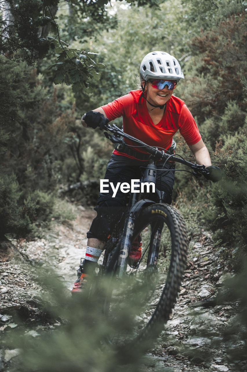 Portrait action shot of young female mountainbiker on trail