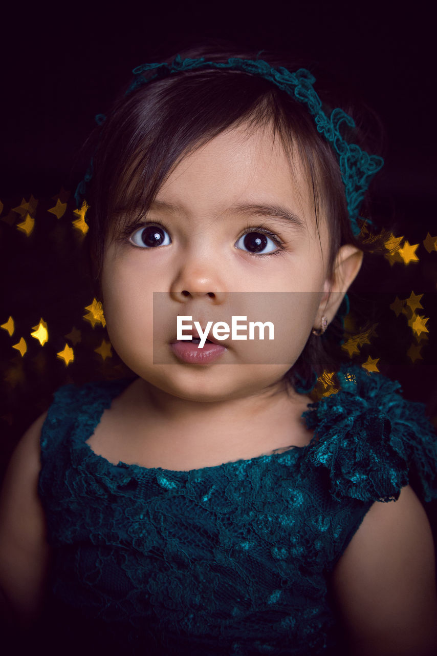 Girl in blue dress in studio with gold sequins and garland