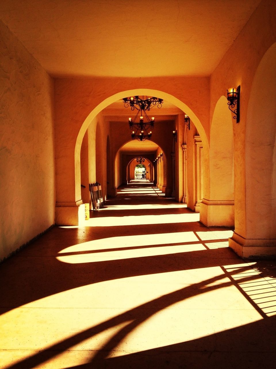 Arched corridor with shadows and hanging lights