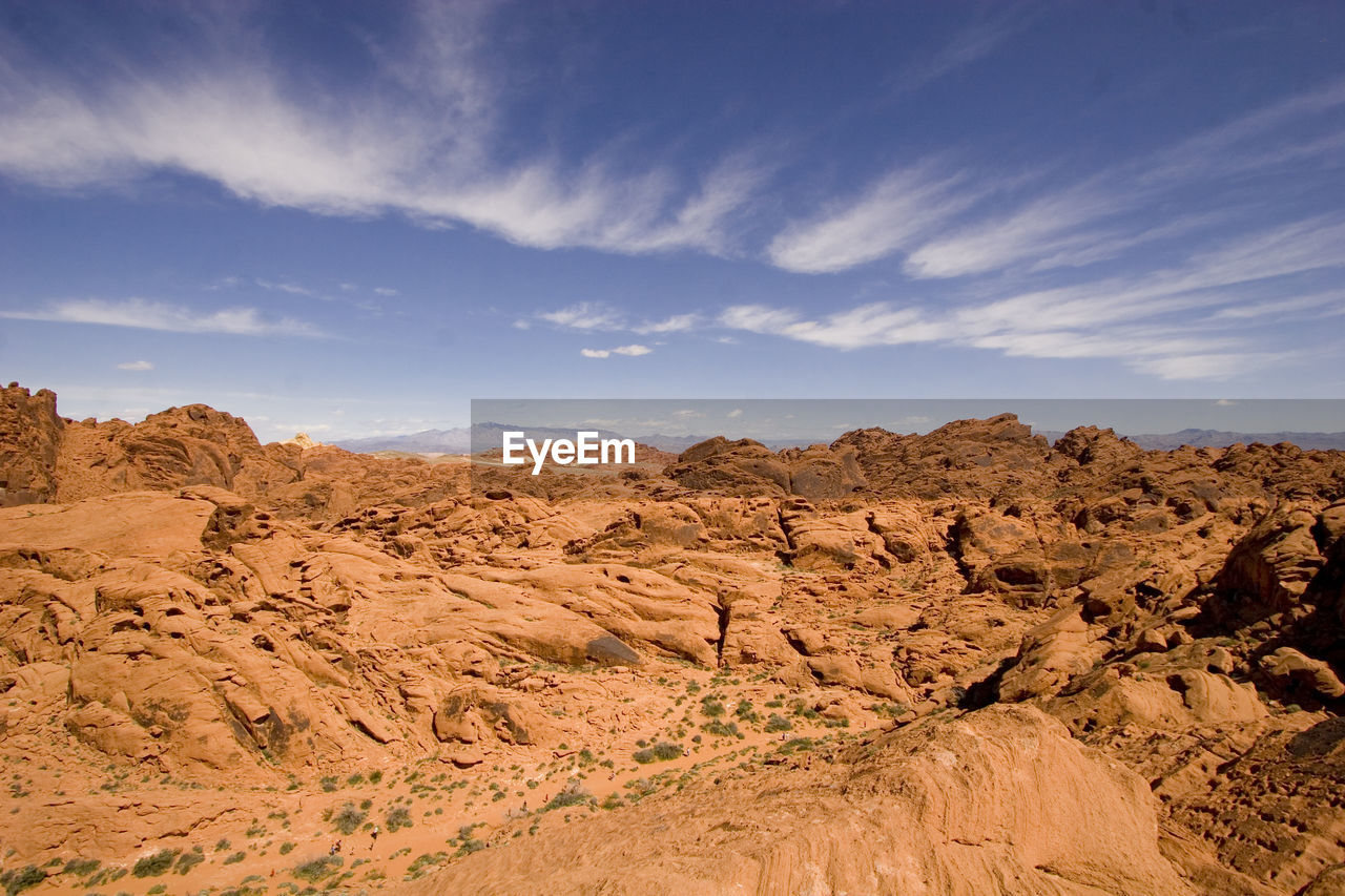 Scenic view of orange desert rocks against sky