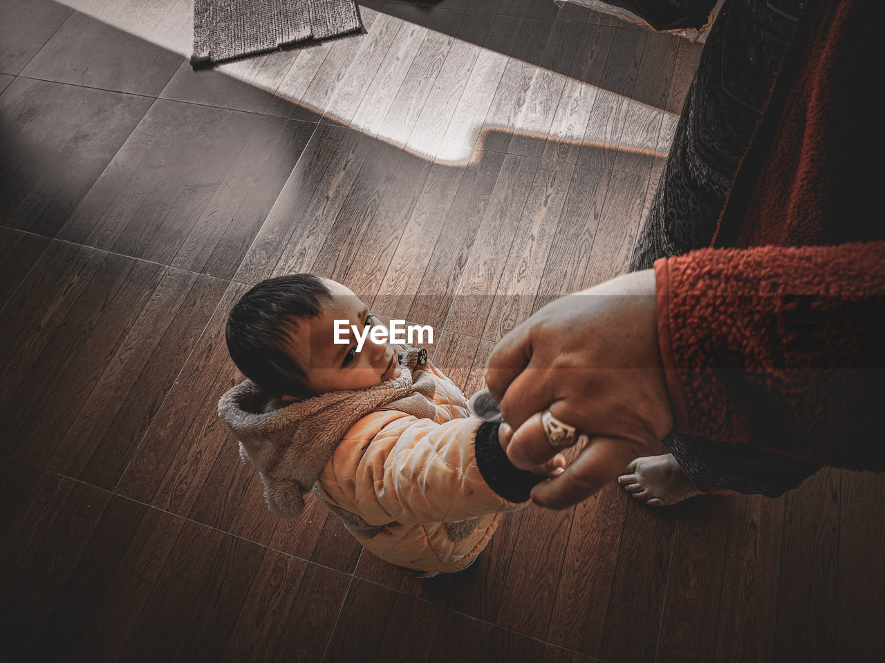 HIGH ANGLE VIEW OF MOTHER WITH BABY ON FLOOR