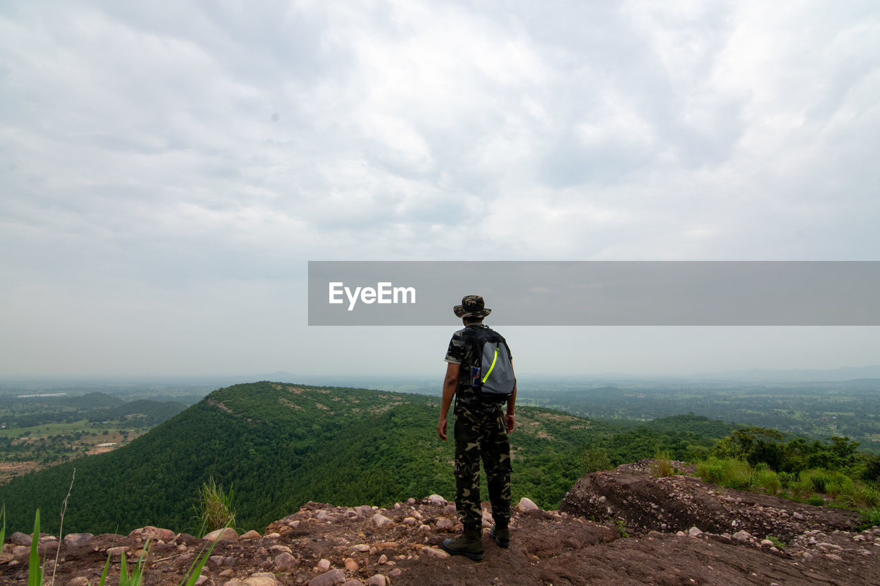 Rear view of hiker standing on mountain witnessing beautiful scene