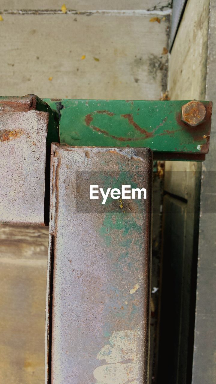 CLOSE-UP OF RUSTY METAL ON WOODEN WALL