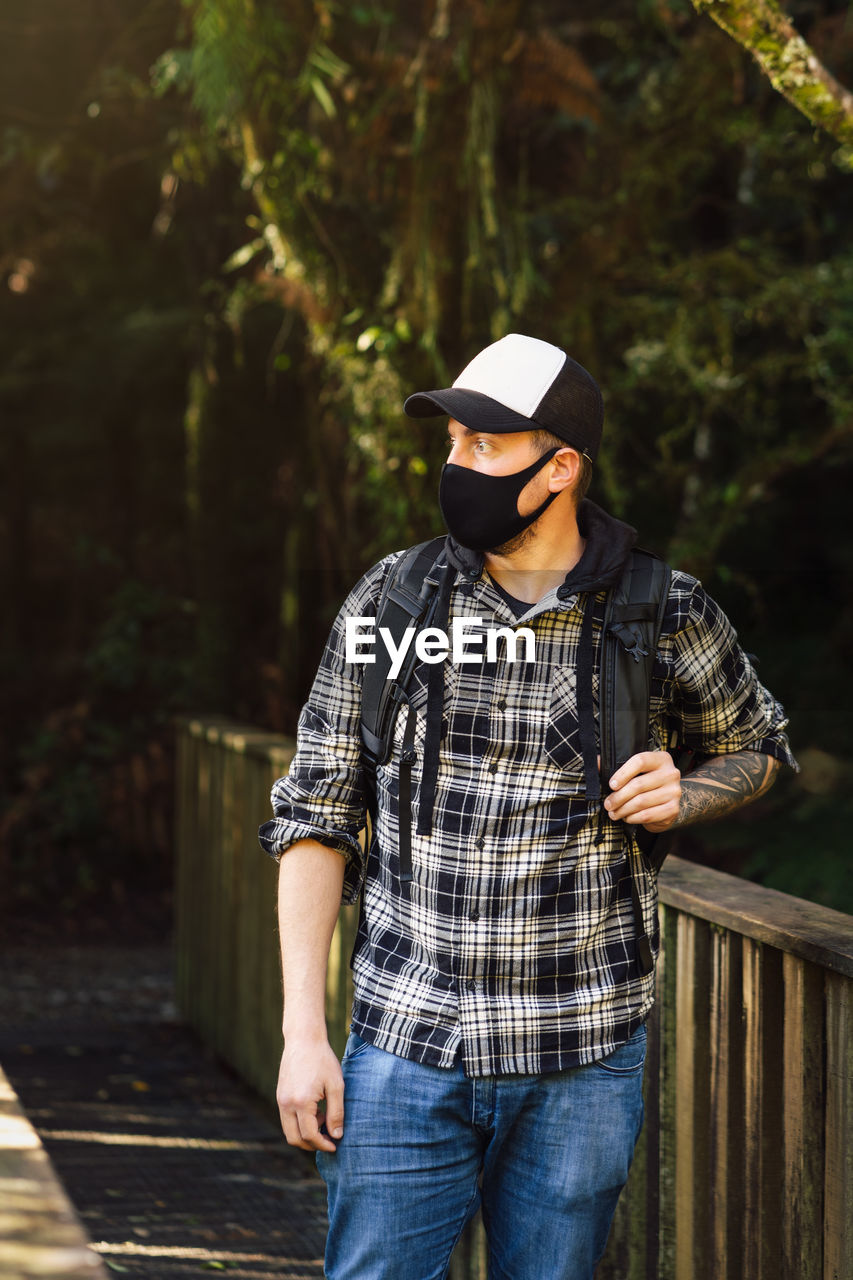 Man wearing mask standing in forest