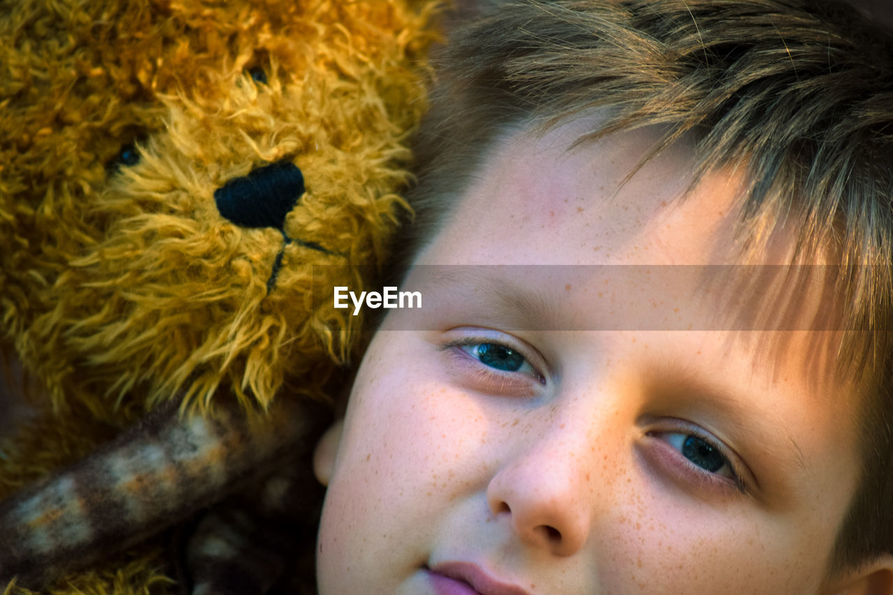 CLOSE-UP PORTRAIT OF CUTE BOY WITH TOY