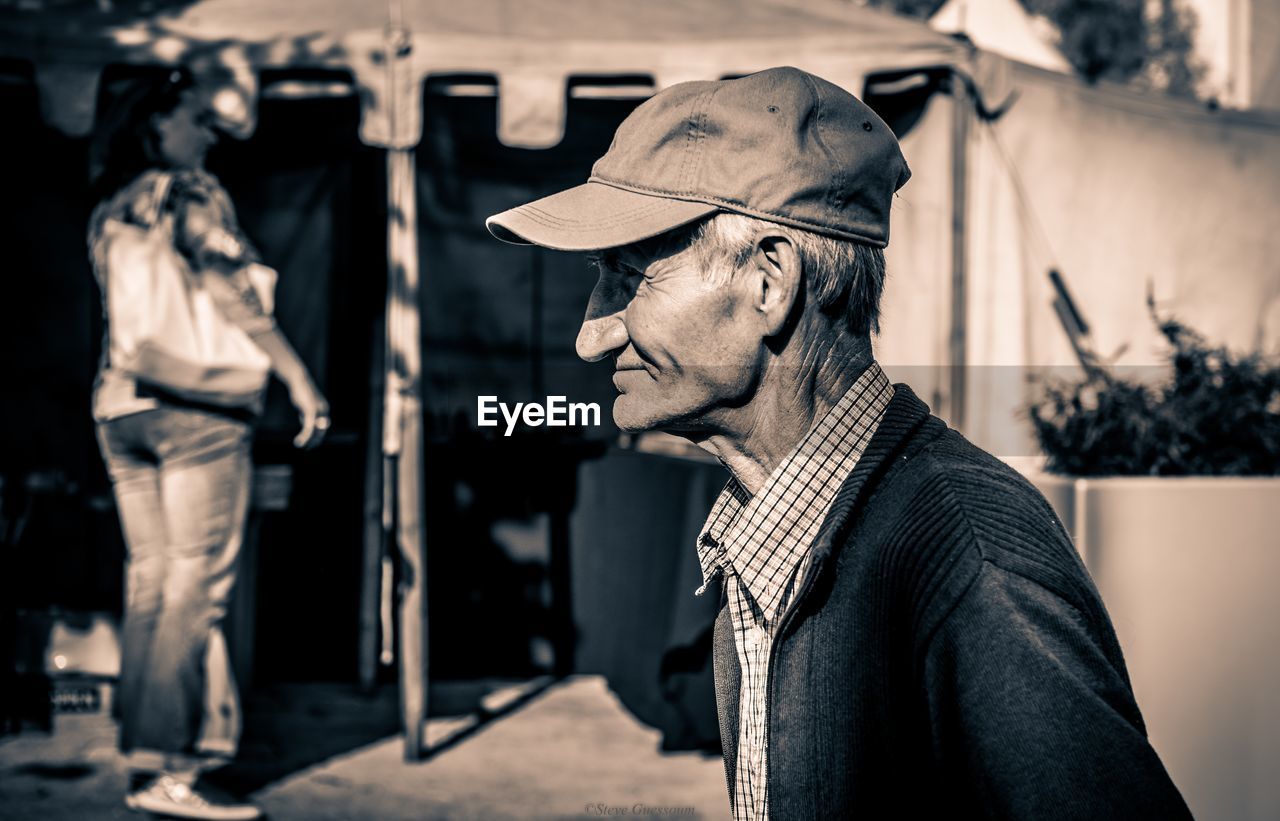 Side view of senior man wearing hat while standing outdoors