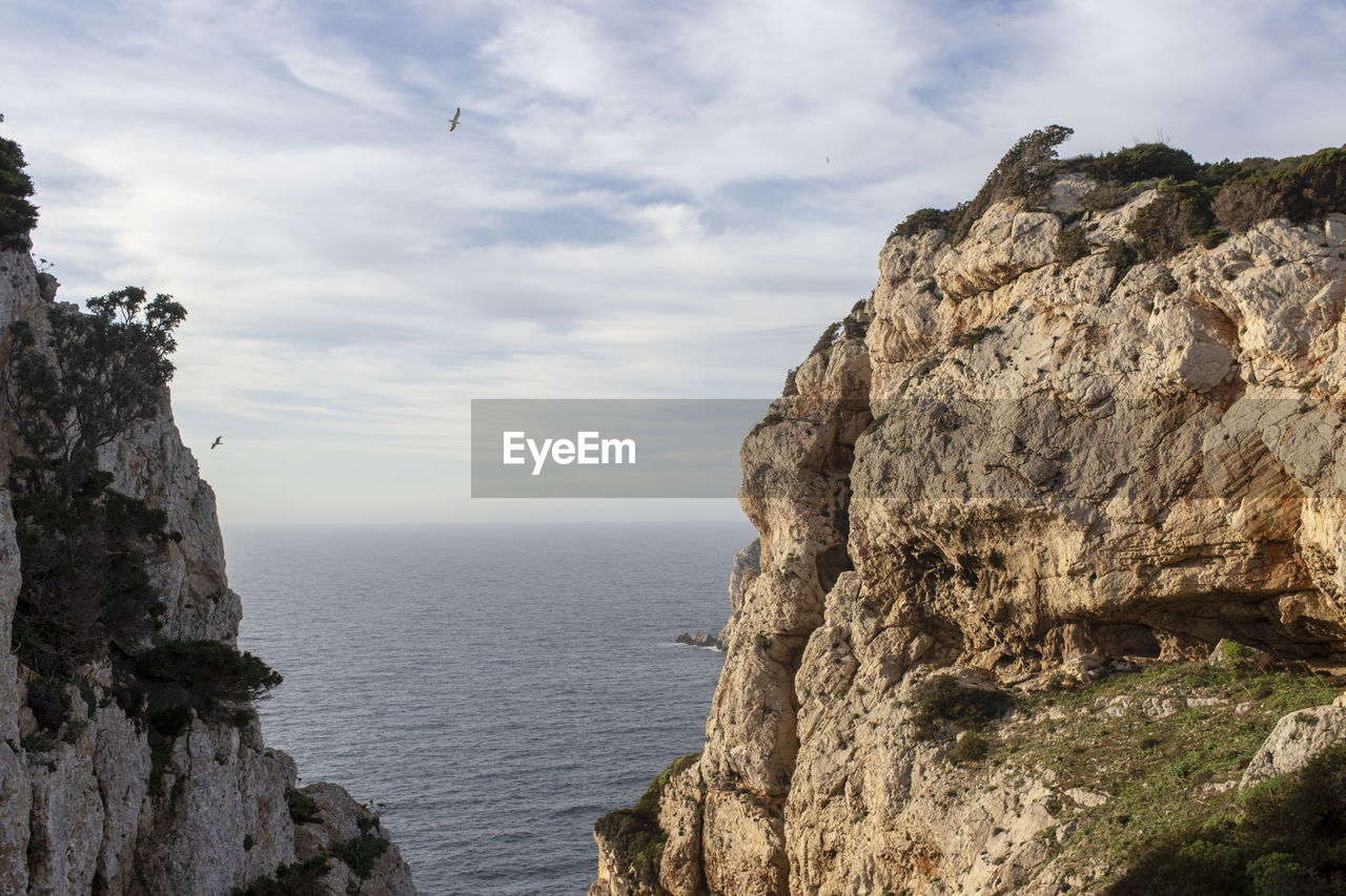 SCENIC VIEW OF SEA AND ROCKS AGAINST SKY