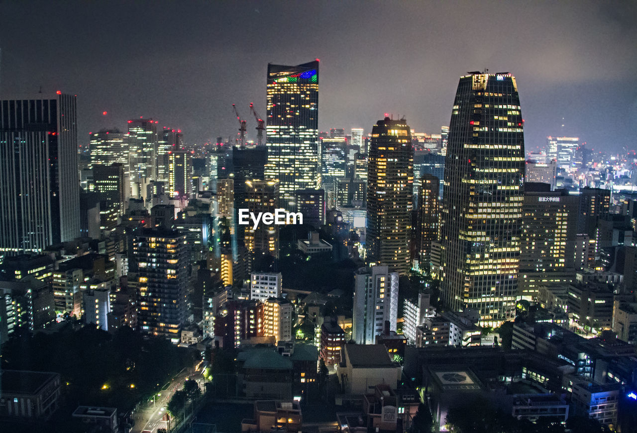 AERIAL VIEW OF ILLUMINATED CITY BUILDINGS AT NIGHT