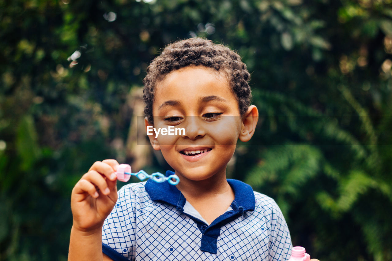 Smiling boy playing with bubble wand