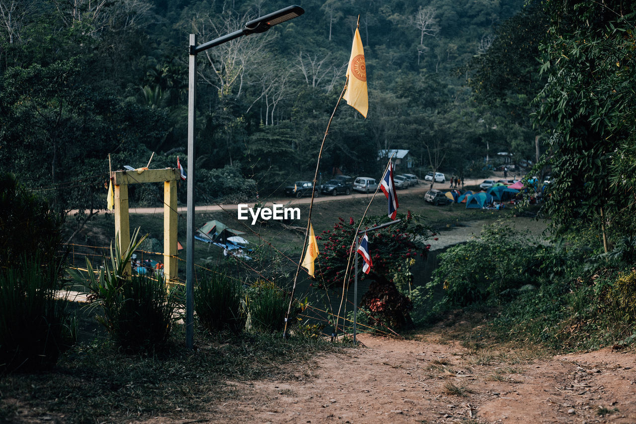 STREET LIGHT HANGING ON FIELD BY TREES