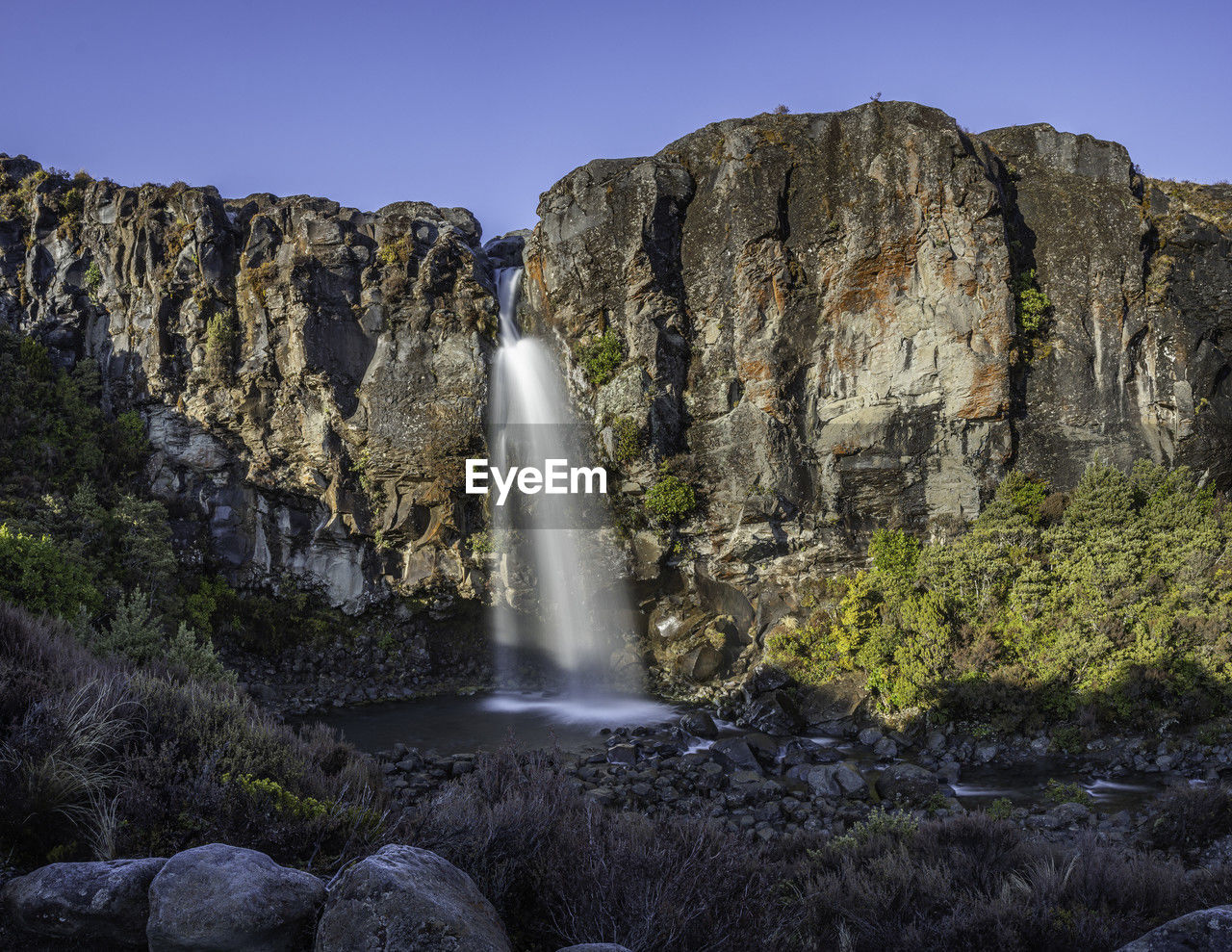 Scenic view of waterfall flowing down a rocky cliff