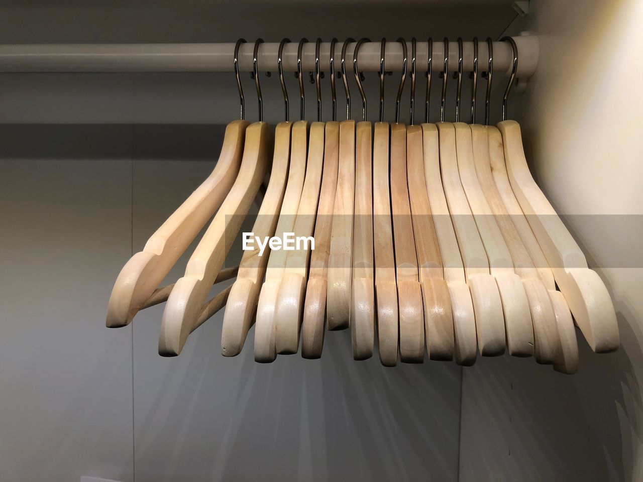 Close-up of wooden coat hangers hanging in rack