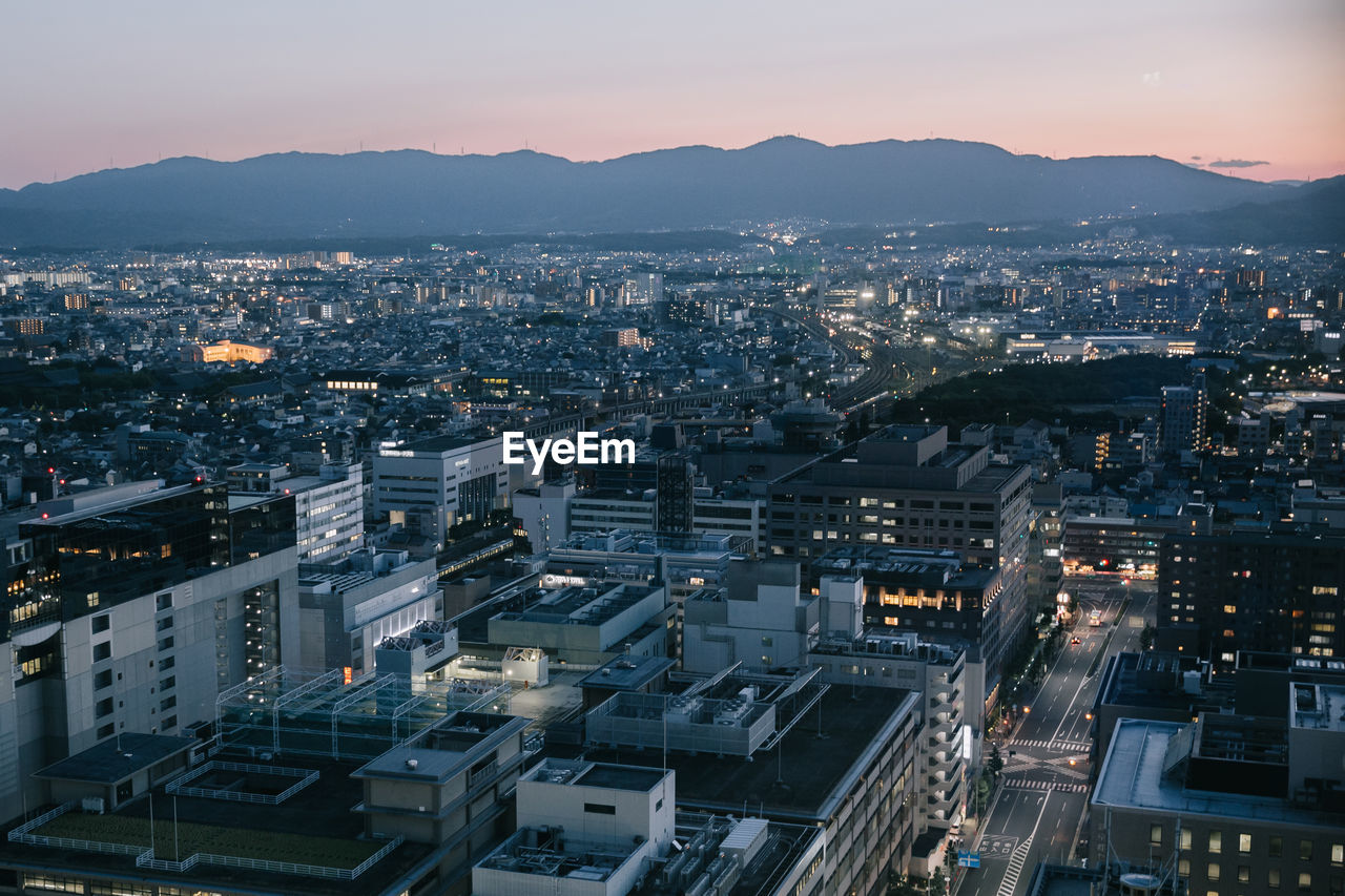 High angle view of illuminated city buildings against sky