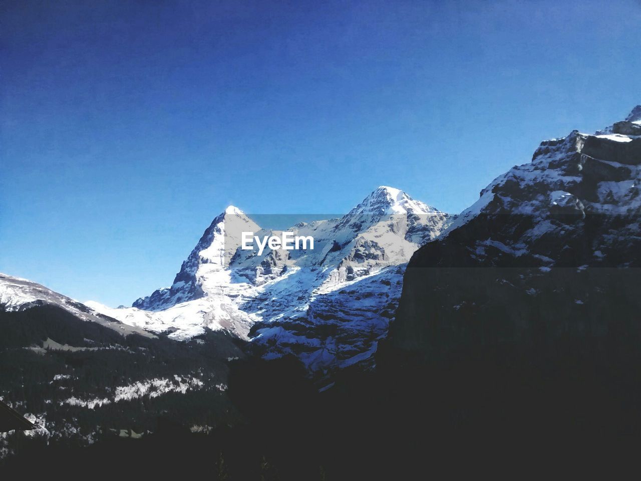 Scenic view of snowcapped mountains against clear blue sky