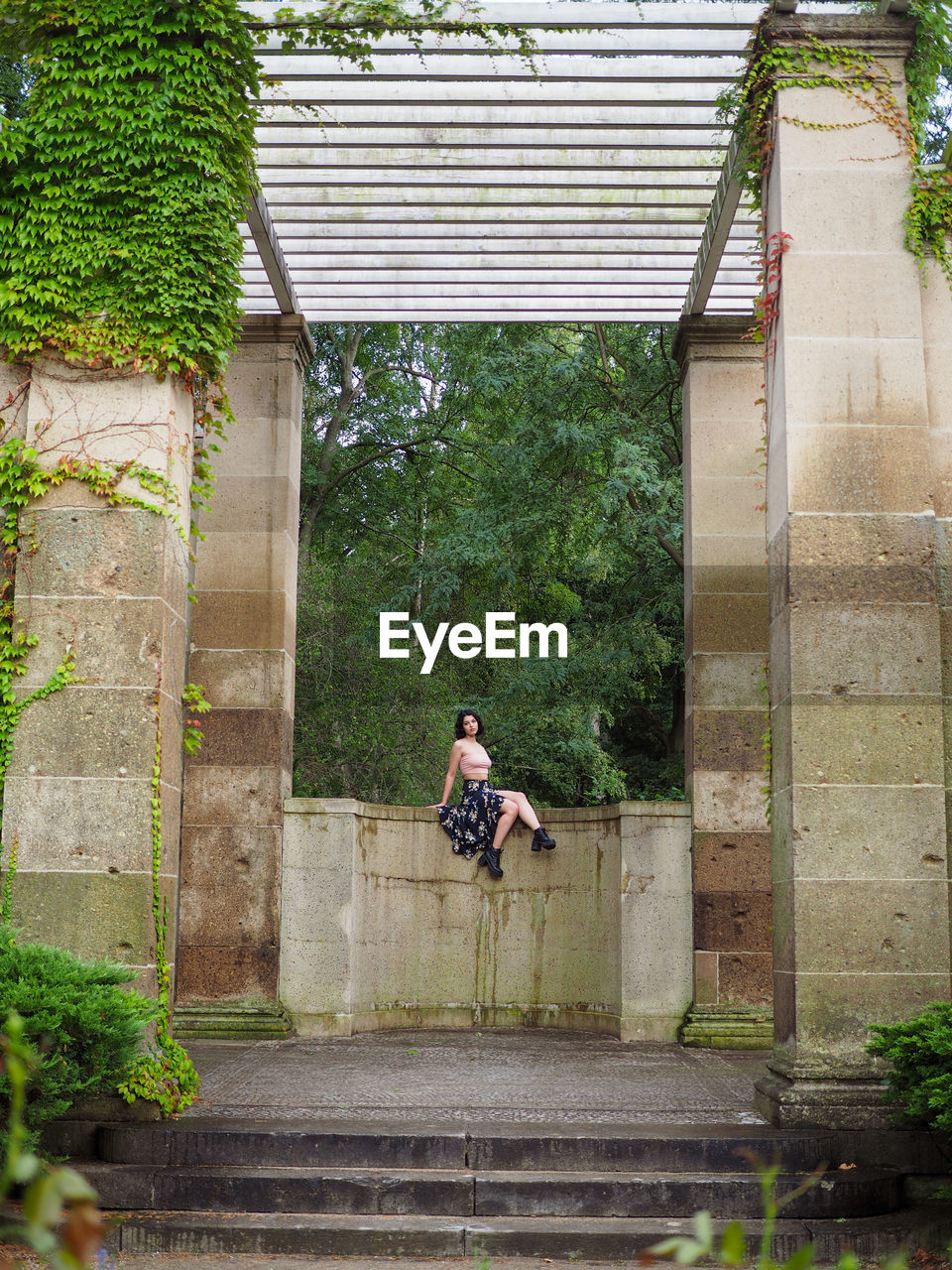 Woman on ledge in the garden