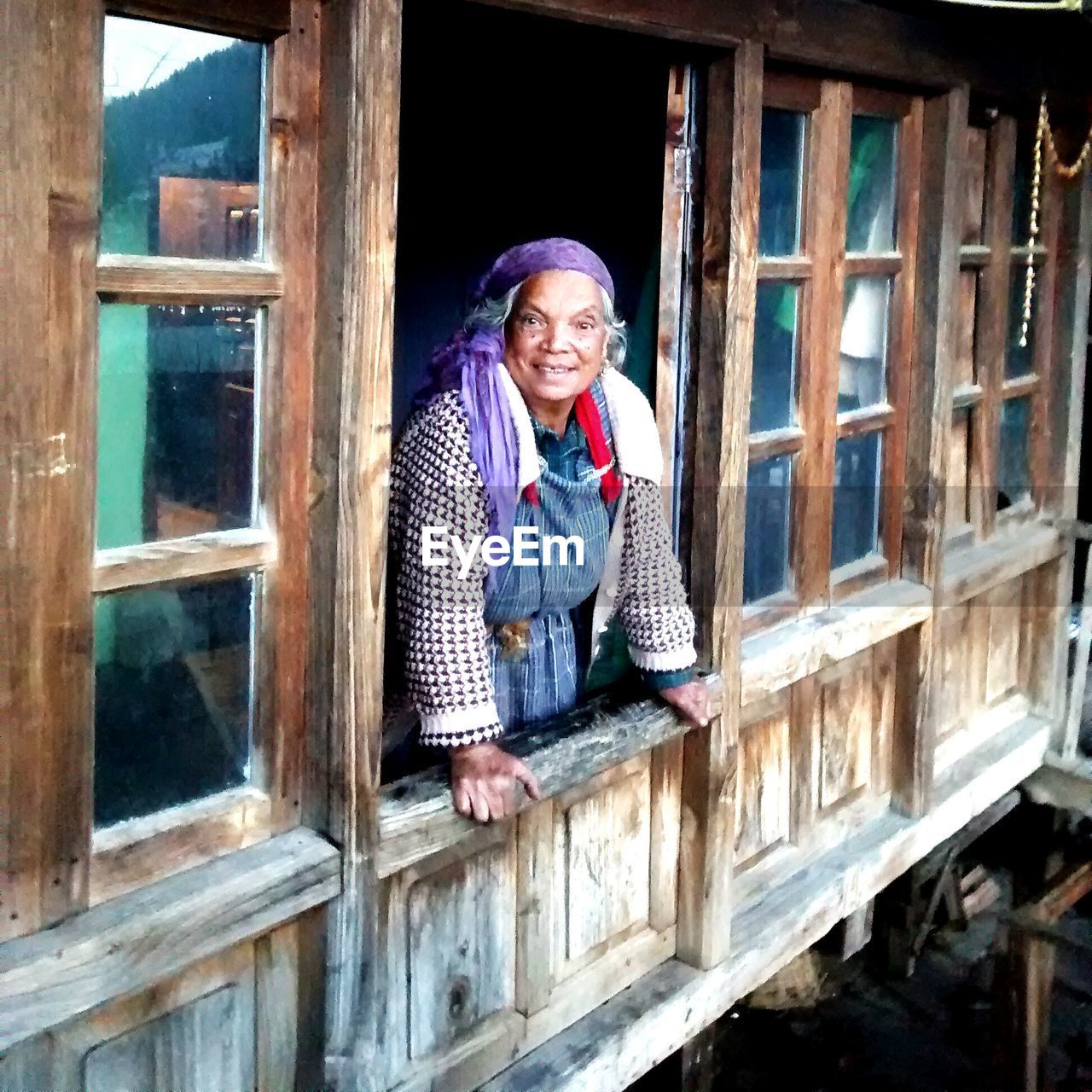 YOUNG WOMAN LOOKING THROUGH WINDOW