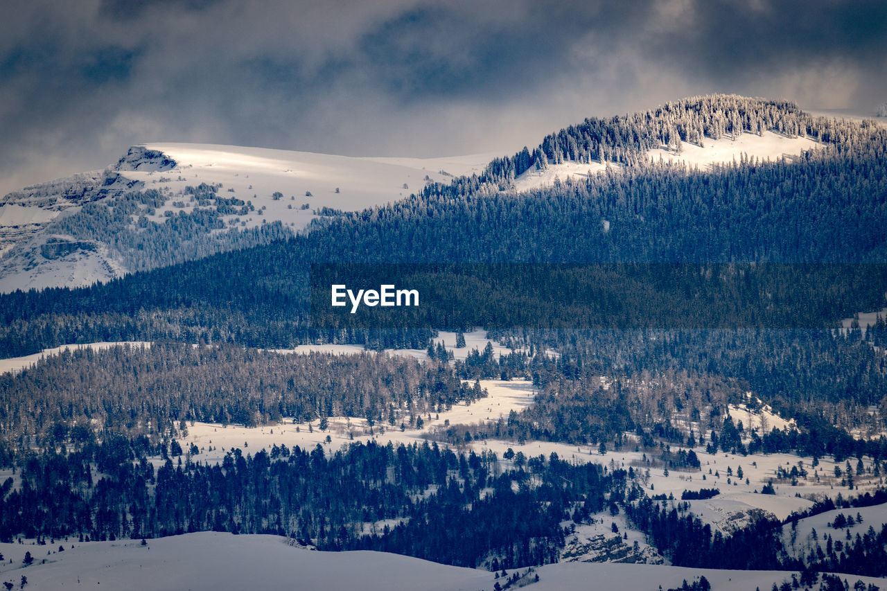 Scenic view of snowcapped mountains against cloudy sky. light and shadow contrast. wyoming,