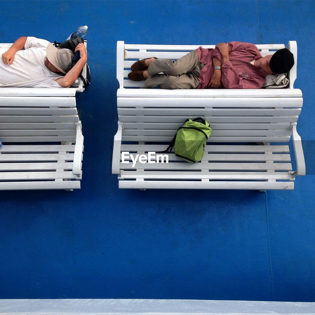 Men relaxing on bench at airport departure area