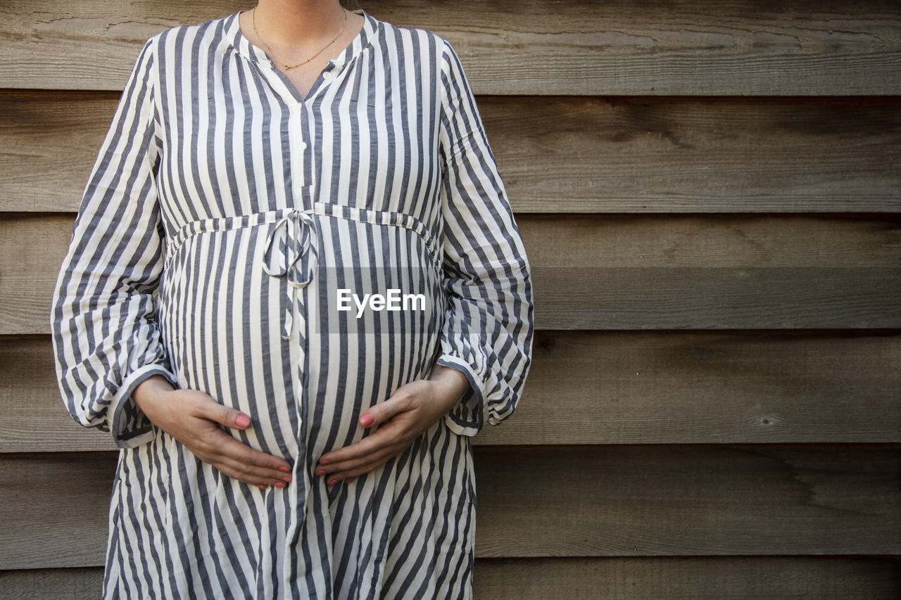 Midsection of woman standing on wood