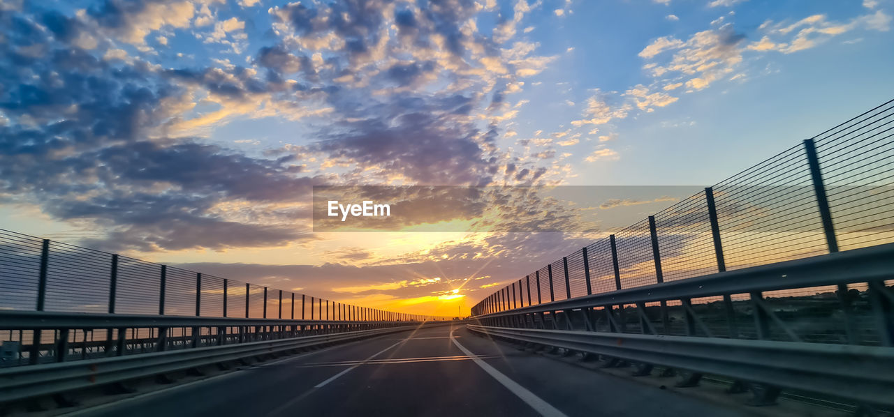 EMPTY ROAD AGAINST SKY DURING SUNSET