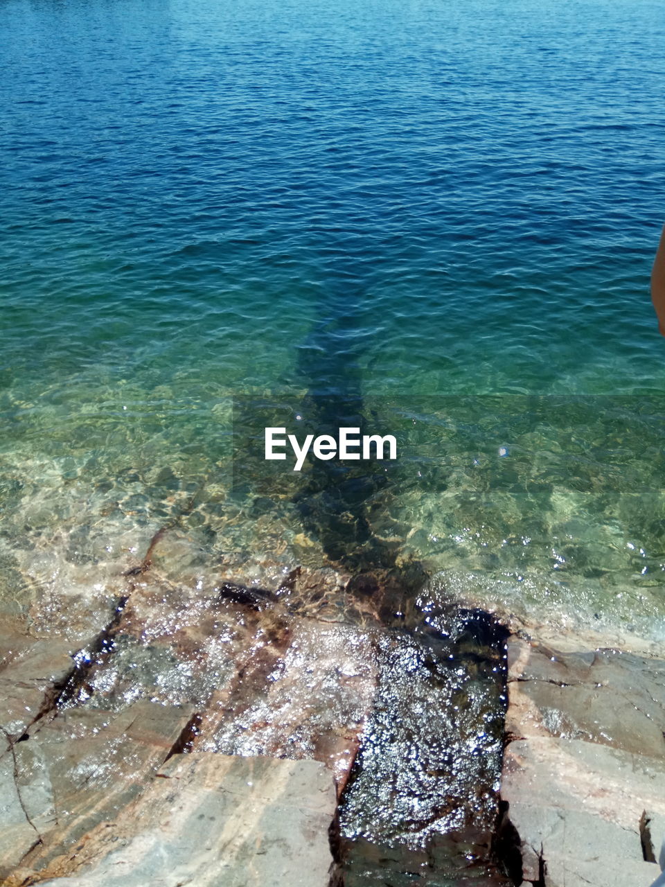 HIGH ANGLE VIEW OF ROCKS ON SEA